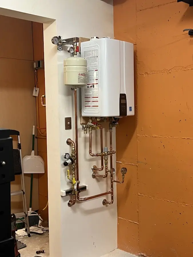 Plumbing technician inspecting water heater connections in Hannahs Mill